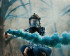 Une femme portant un masque à gaz et tenant une fusée bleue devant un fond d'arbres.