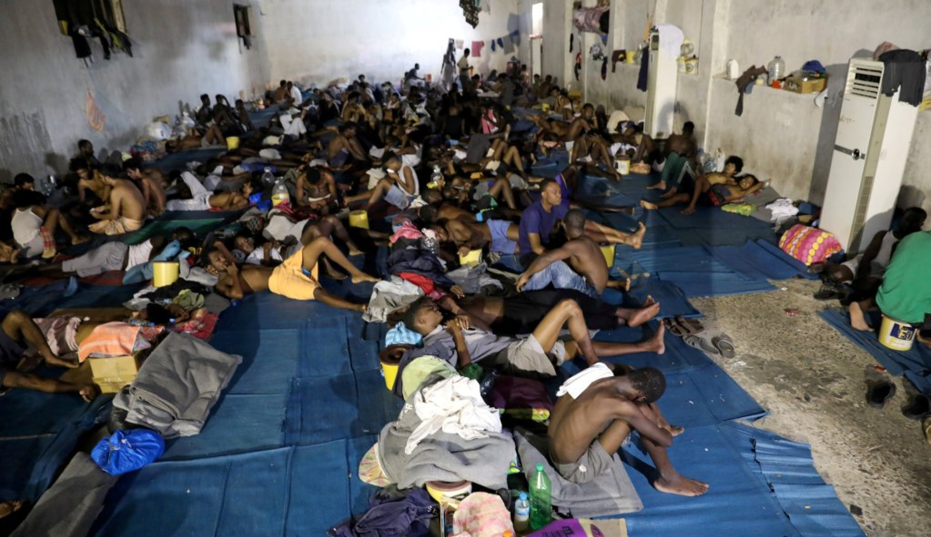 centaine d'enfants couchés dans une grande salle