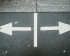 Flèches pointant dans des directions opposées sur une rue