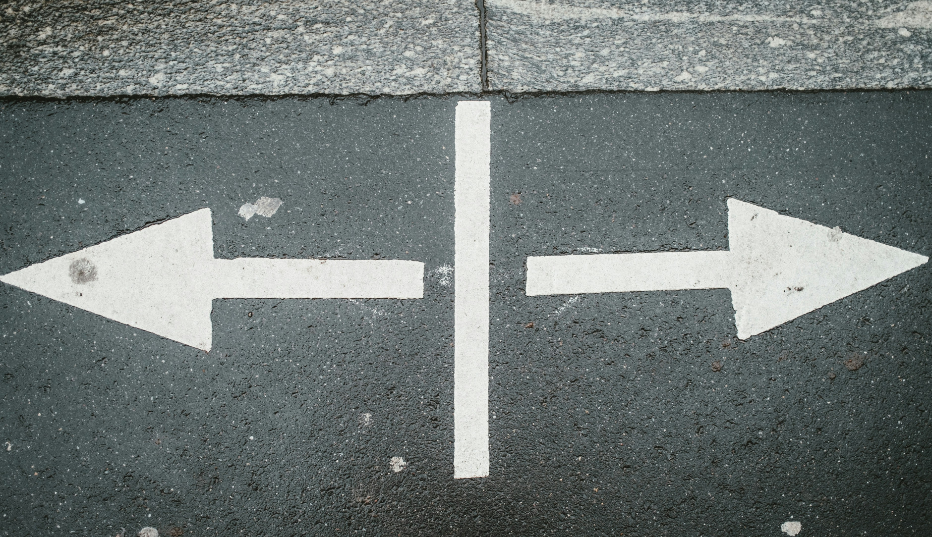 Flèches pointant dans des directions opposées sur une rue