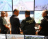 5 hommes discutant de dos devant des écrans