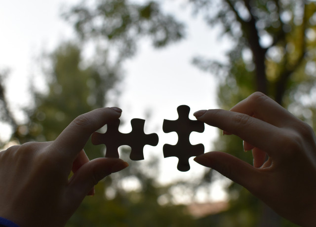 Mains tenant deux pièces de puzzle