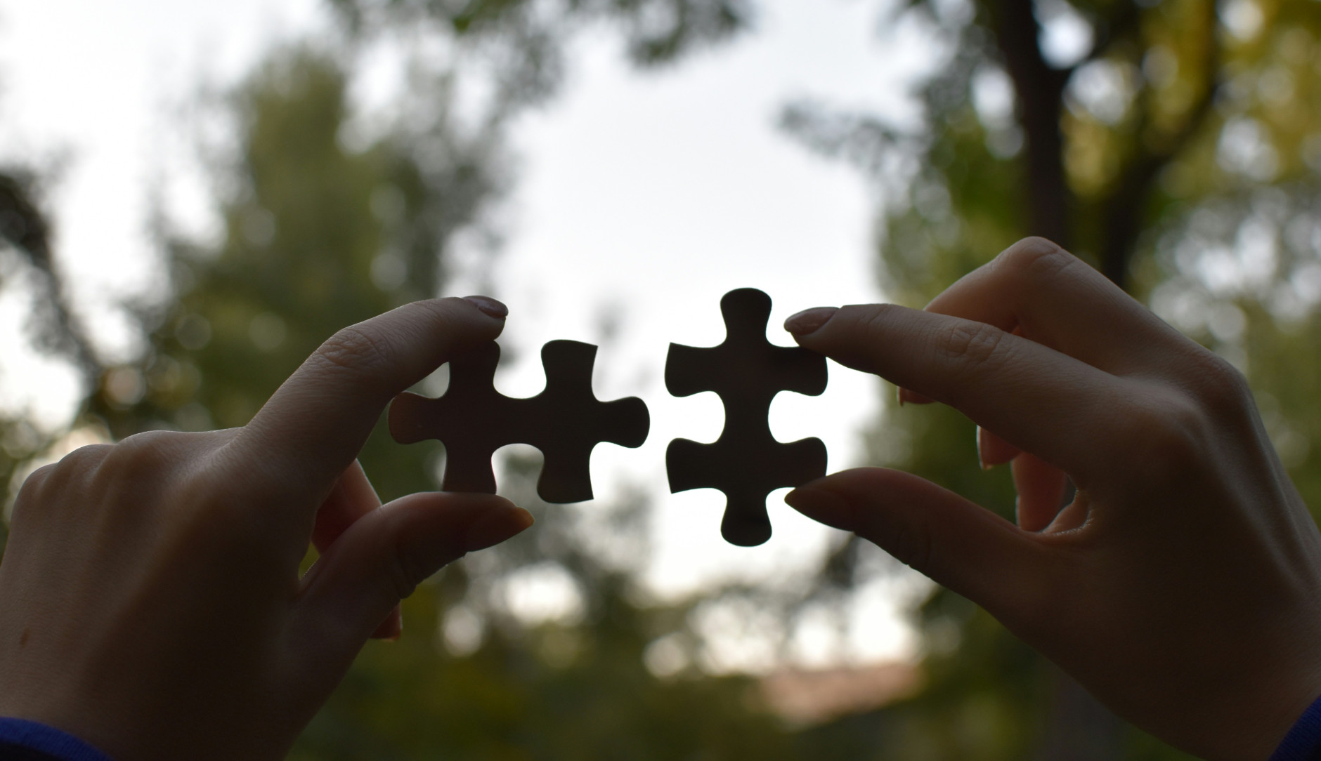 Mains tenant deux pièces de puzzle