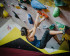 a dark haired woman working her way up a climbing wall