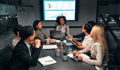 Un groupe animé discutant sous un écran de présentation