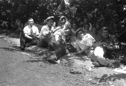 des hommes et des femmes allongé à l'ombre au bord d'un chemin