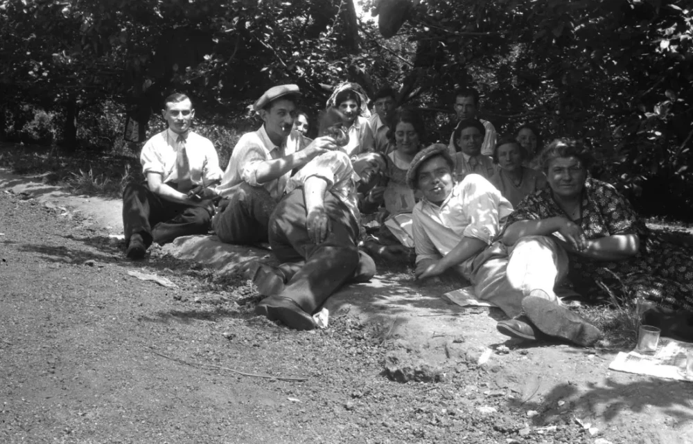 des hommes et des femmes allongé à l'ombre au bord d'un chemin
