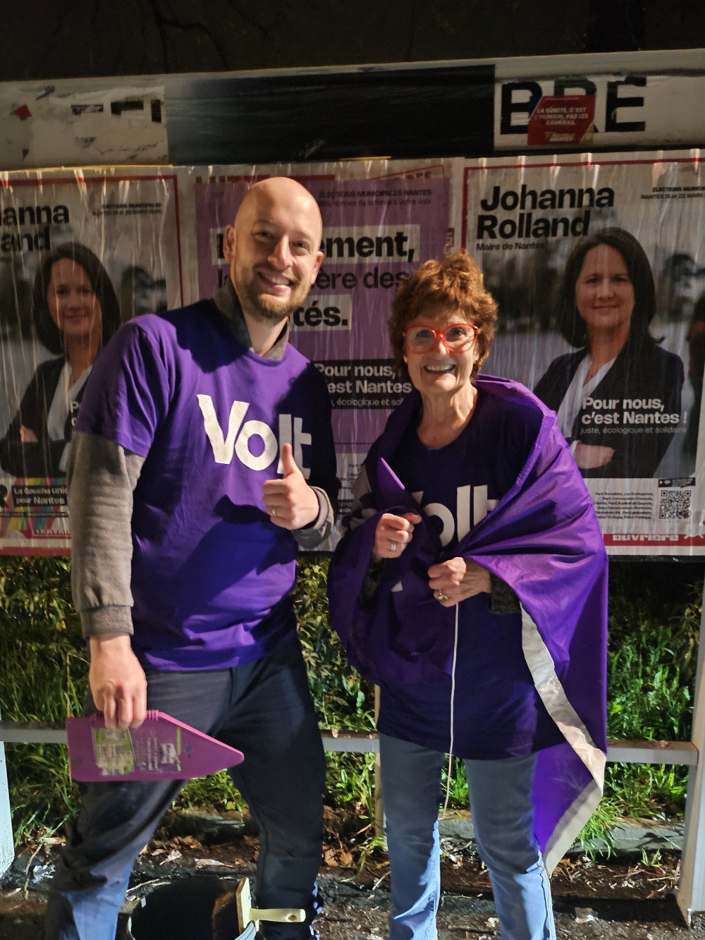 Adrien et Christine devant panneaux d'affichage