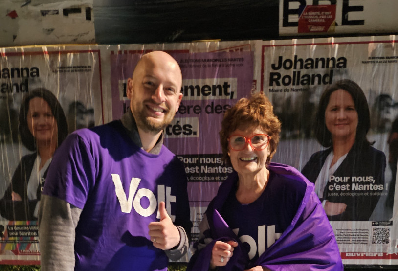 Adrien et Christine devant panneaux d'affichage