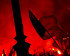 Drapeau flottant devant un monument avec des torches rouges allumées