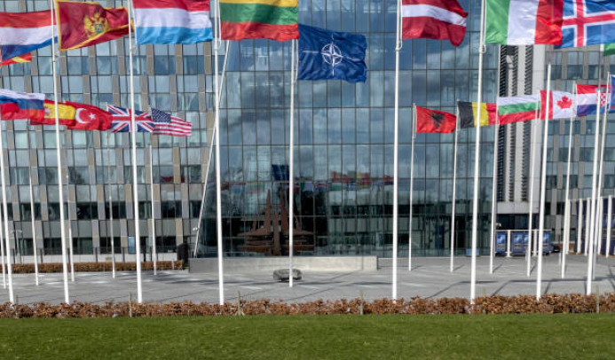 drapeau de l'otan et autres devant facade vitrée