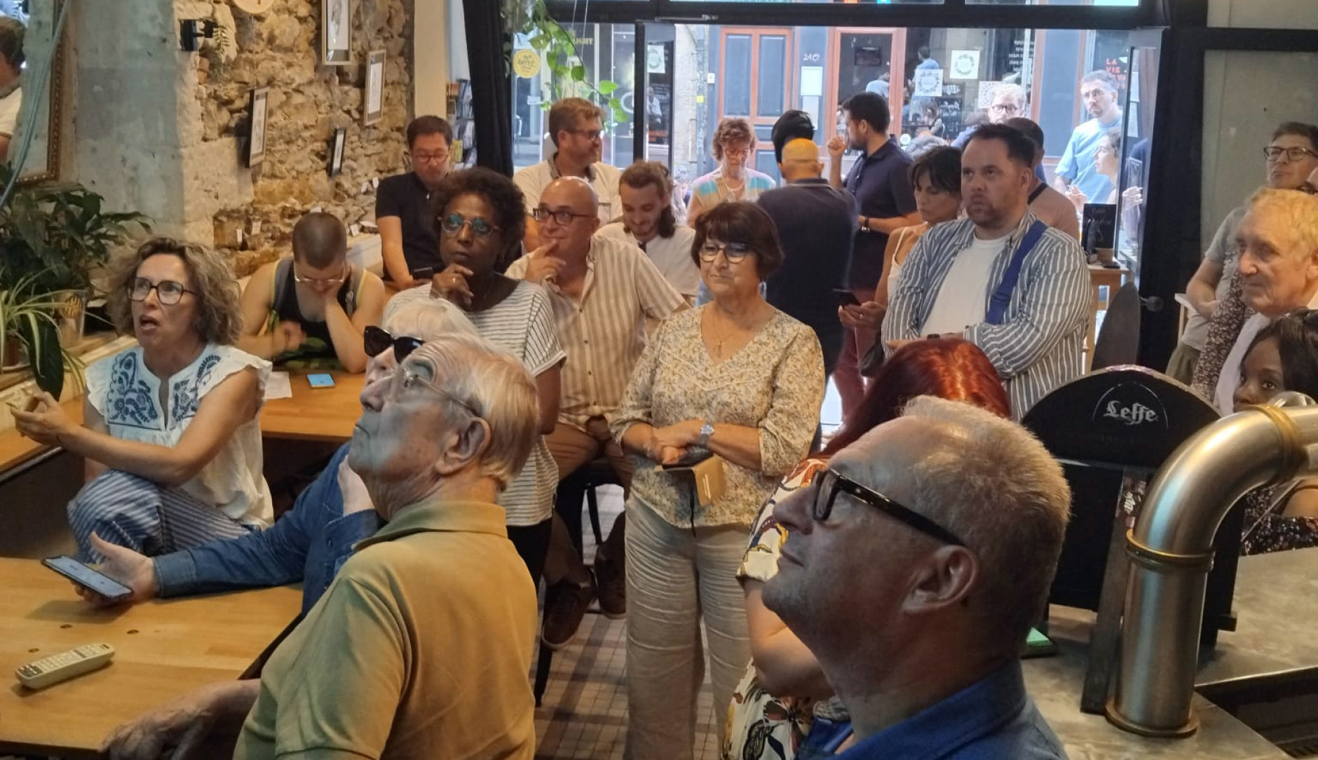 Groupe de personnes dans un bar telephone à la main