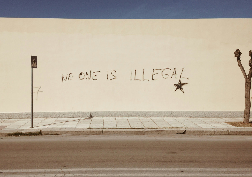 Un mur avec un graffiti disant « personne n'est illégal ».