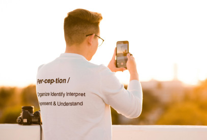 Un photographe portant un t-shirt sur lequel figure la définition du mot « perception »
