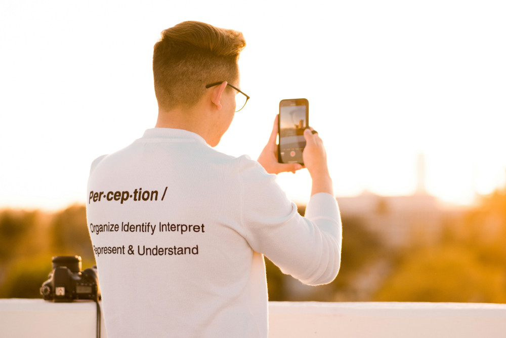 Un photographe portant un t-shirt sur lequel figure la définition du mot « perception »