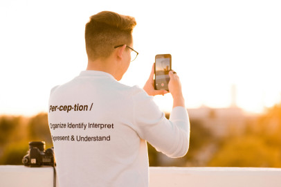 Un photographe portant un t-shirt sur lequel figure la définition du mot « perception »