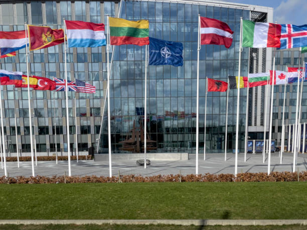 drapeau de l'otan et autres devant facade vitrée