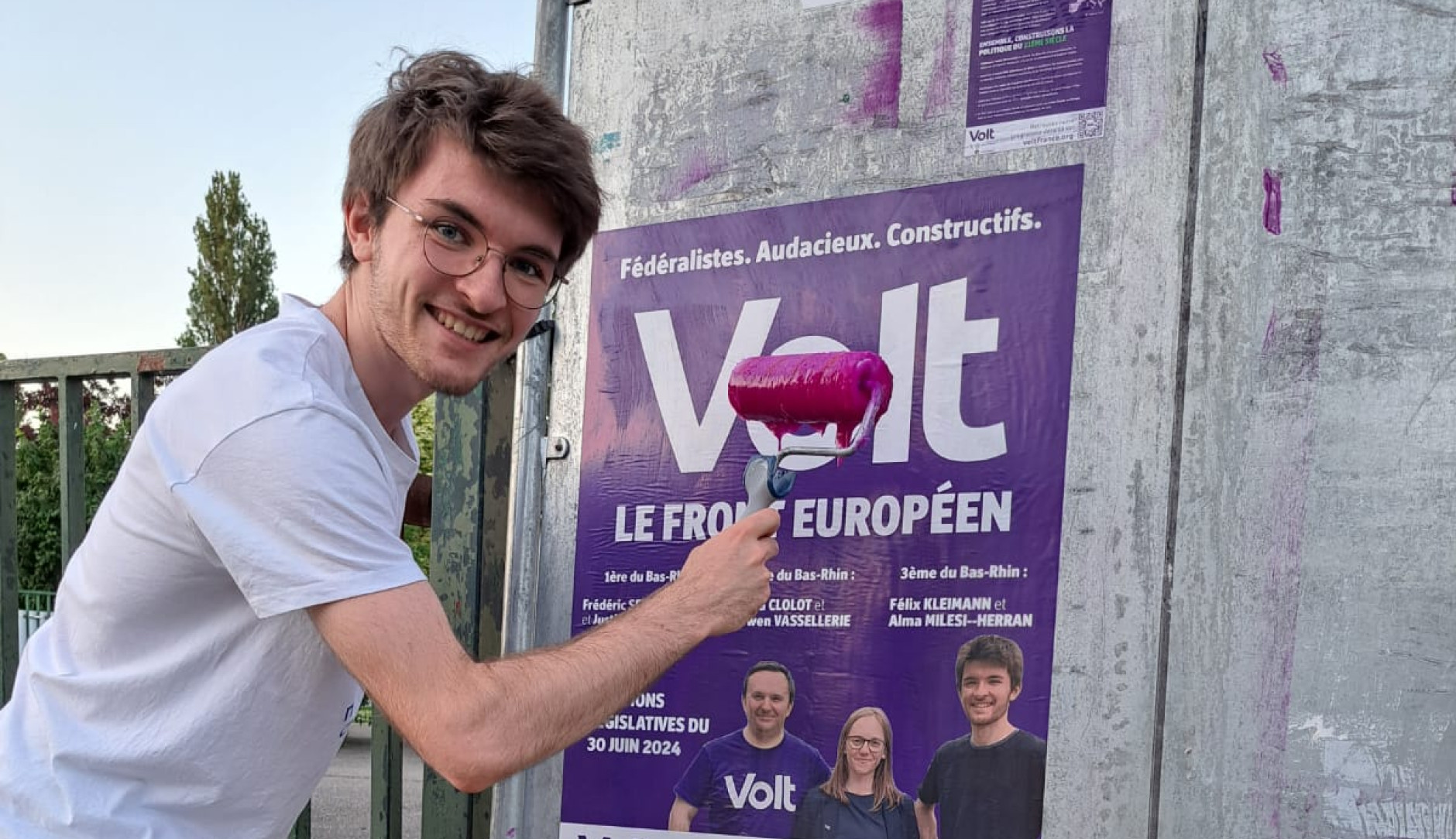 Le candidat Volt Felix Kleimann colle une affiche Volt