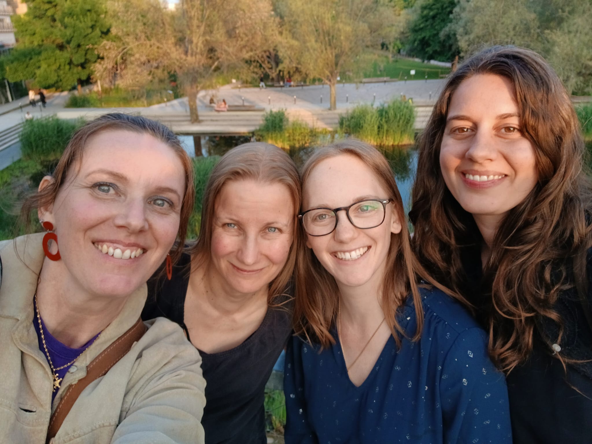 4 jeunes femmes souriantes dans un jardin avec bassin